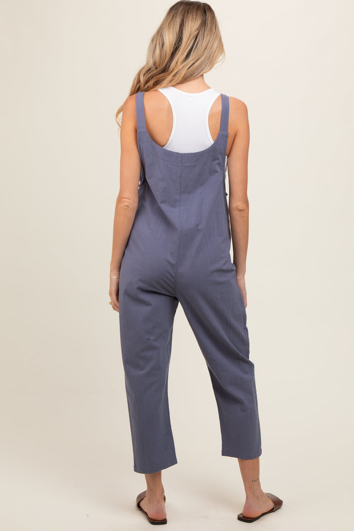 woman wearing a navy blue maternity jumpsuit with cropped legs and adjustable straps, seen from the back