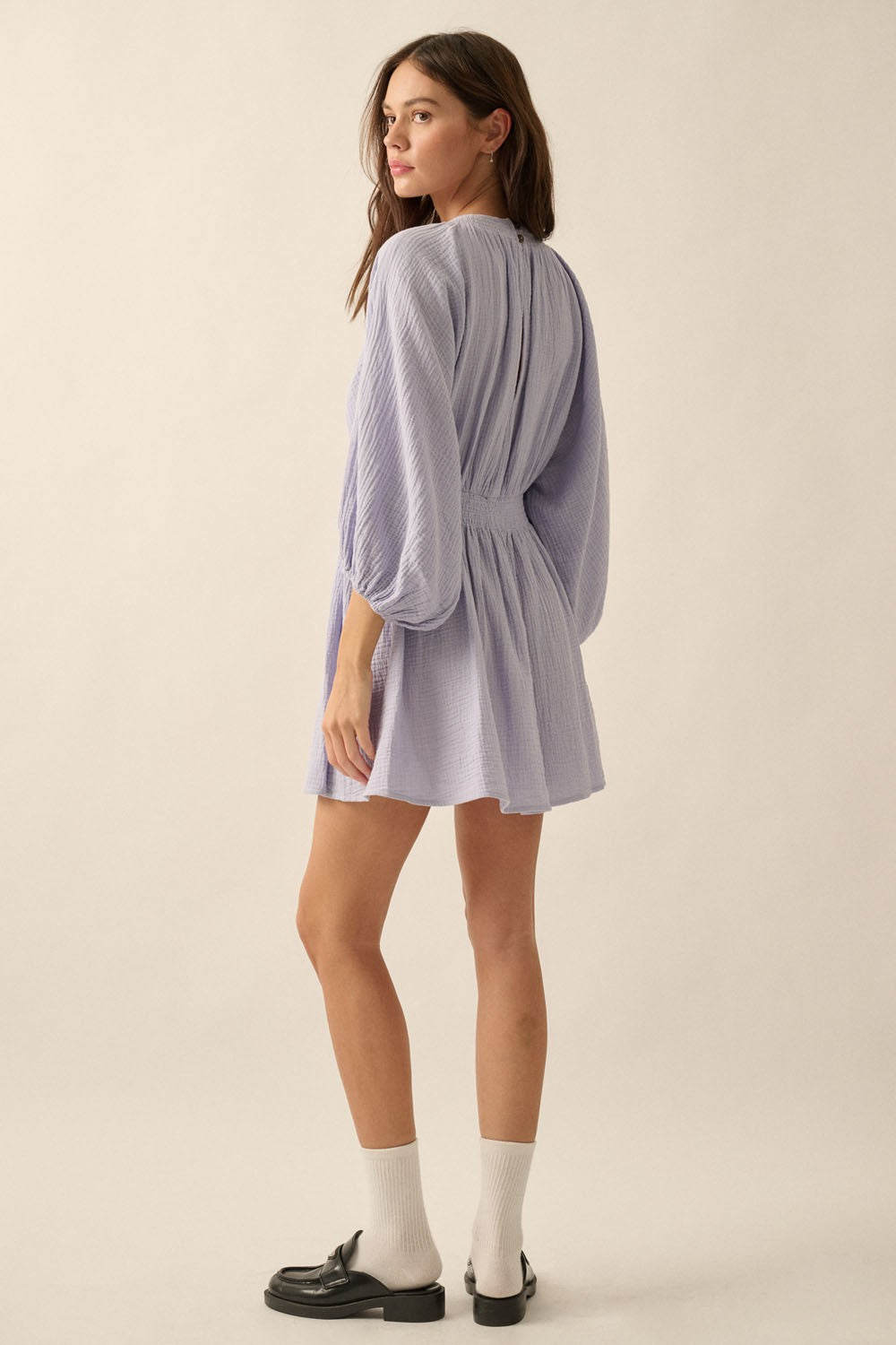 woman wearing a lavender long sleeve mini dress with a cinched waist and puff sleeves