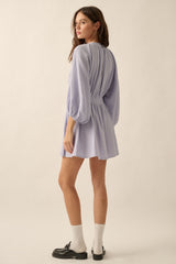 woman wearing a lavender long sleeve mini dress with a cinched waist and puff sleeves