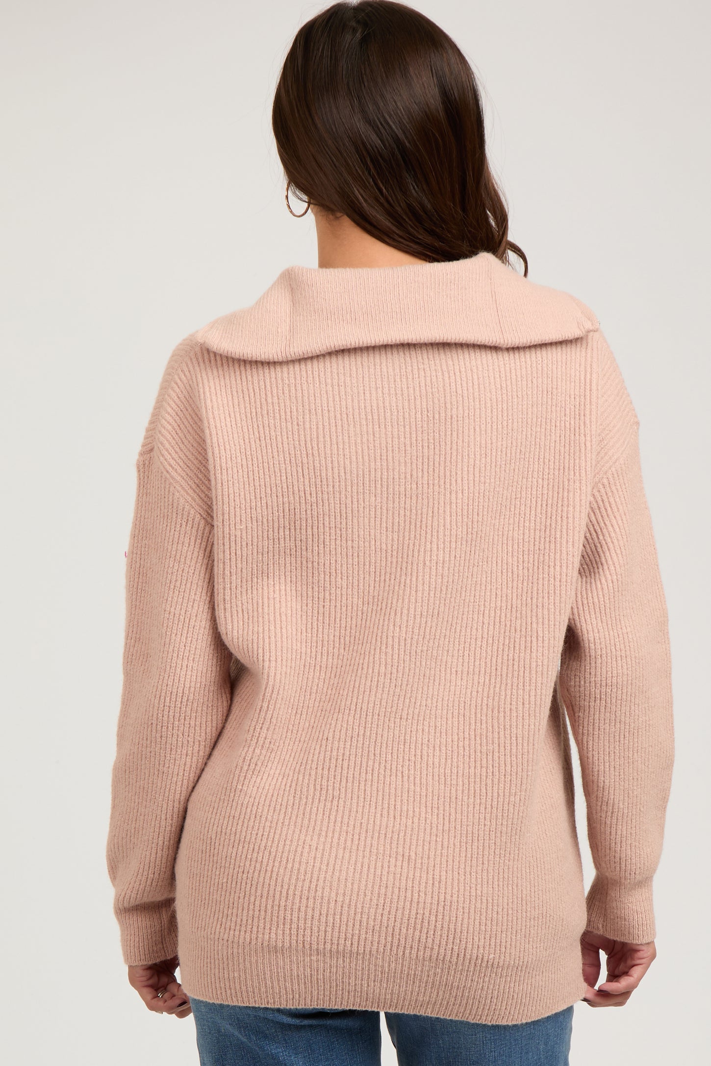 woman wearing a soft pink maternity sweater with a relaxed fit and ribbed texture, viewed from the back