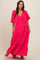 woman wearing a bright pink maternity maxi dress with flutter sleeves and a flowy skirt, showing her baby bump