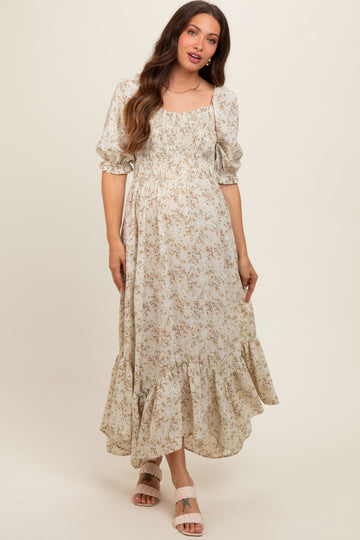 woman wearing a floral maternity maxi dress with puff sleeves and a ruffled hemline