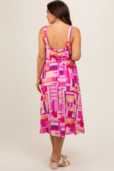 woman wearing a colorful patterned maternity dress with a V-back design and flowy skirt