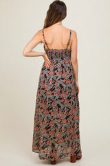 woman wearing a black floral maternity maxi dress with adjustable straps and a smocked back, showing her baby bump