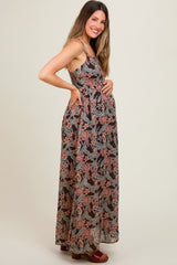 woman wearing a floral print maternity maxi dress with a fitted bodice and flowy skirt, highlighting her baby bump