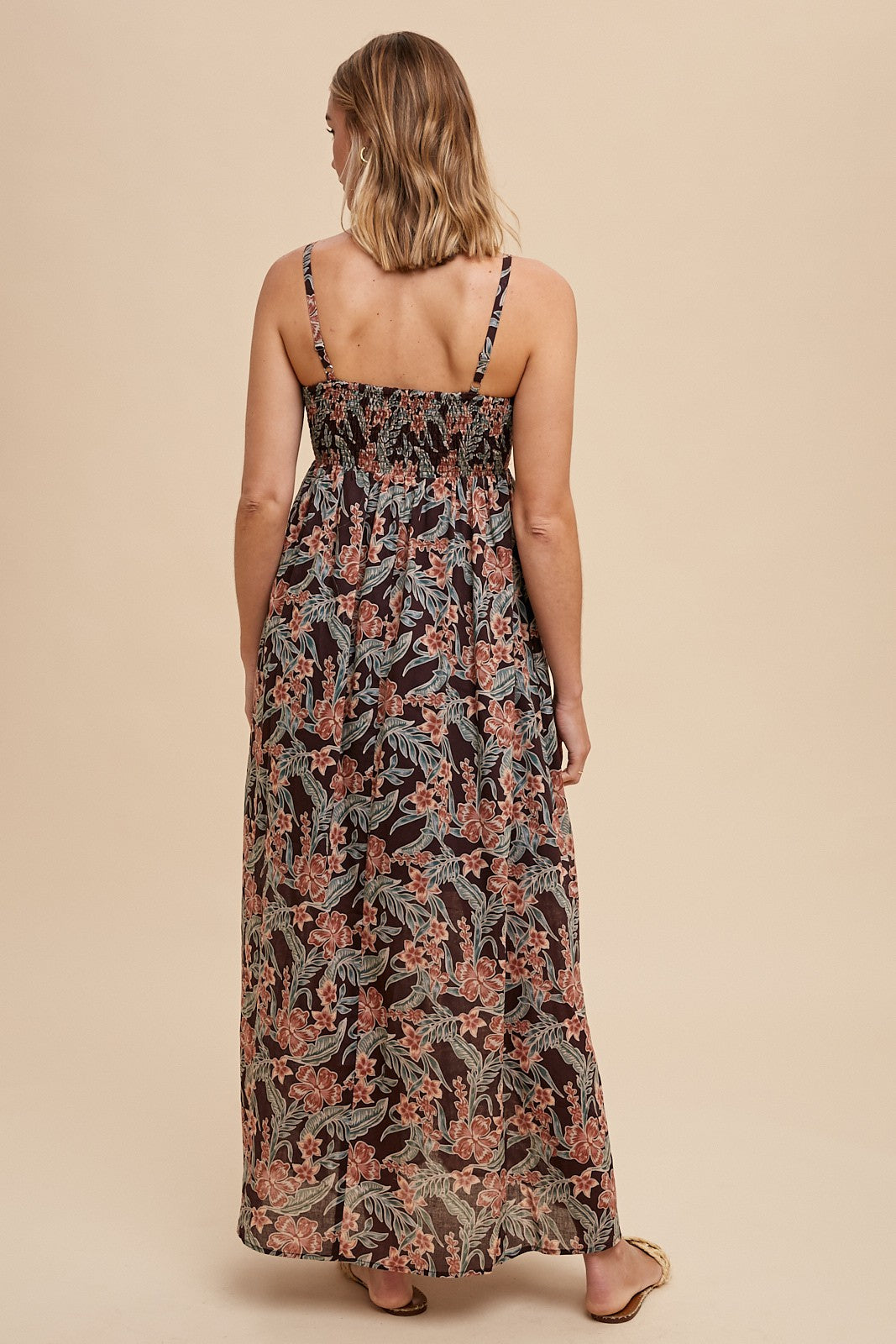 woman wearing a black floral maxi dress with a smocked back and thin shoulder straps