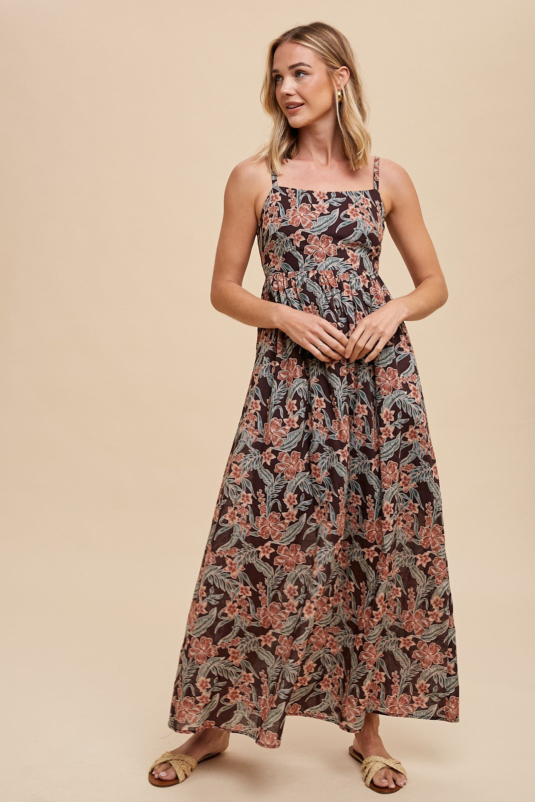 woman wearing a black floral maxi dress with spaghetti straps and a fitted bodice