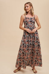woman wearing a black floral maxi dress with spaghetti straps and a fitted bodice