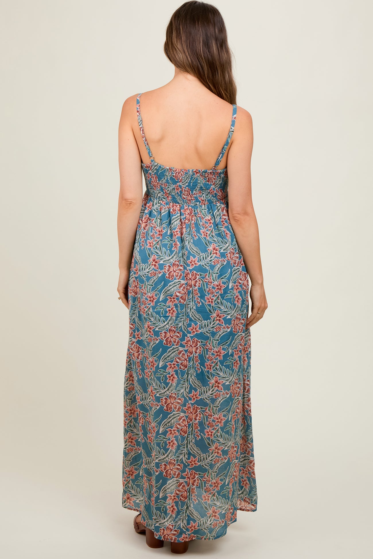 woman wearing a floral patterned maternity maxi dress with adjustable straps and a smocked back detail