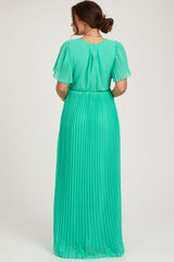 woman wearing a green pleated maternity maxi dress with short sleeves and a gathered waist, showing the back view
