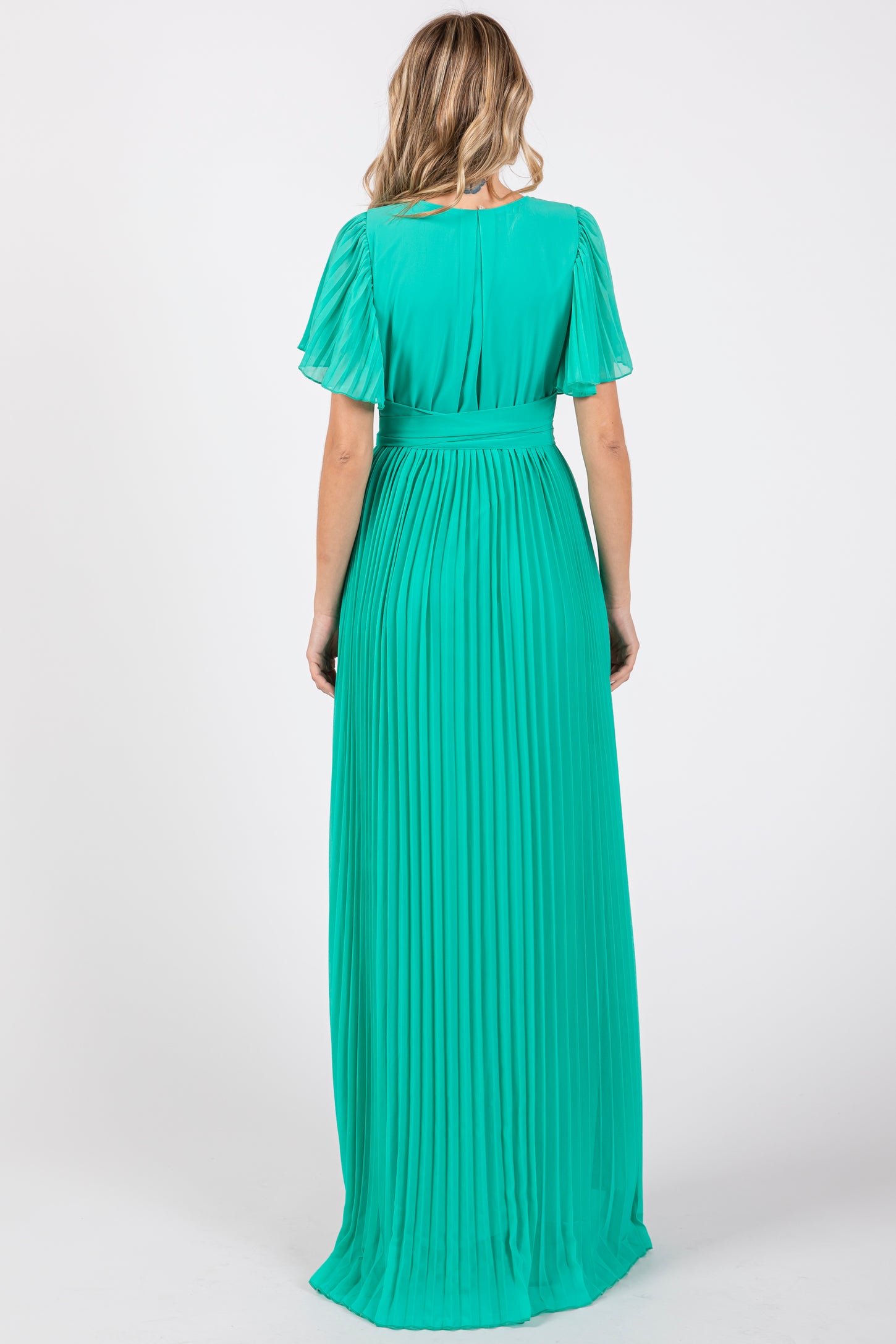 woman wearing a pleated back view mint green maxi dress with flutter sleeves and a cinched waist