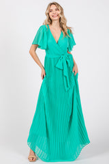 woman wearing a pleated mint green maxi dress with flutter sleeves and a waist tie