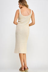 woman wearing a light beige ribbed knit midi dress with a scoop back and side slit