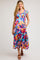 woman wearing a colorful floral maternity dress with ruffled sleeves and tiered skirt, showing her baby bump