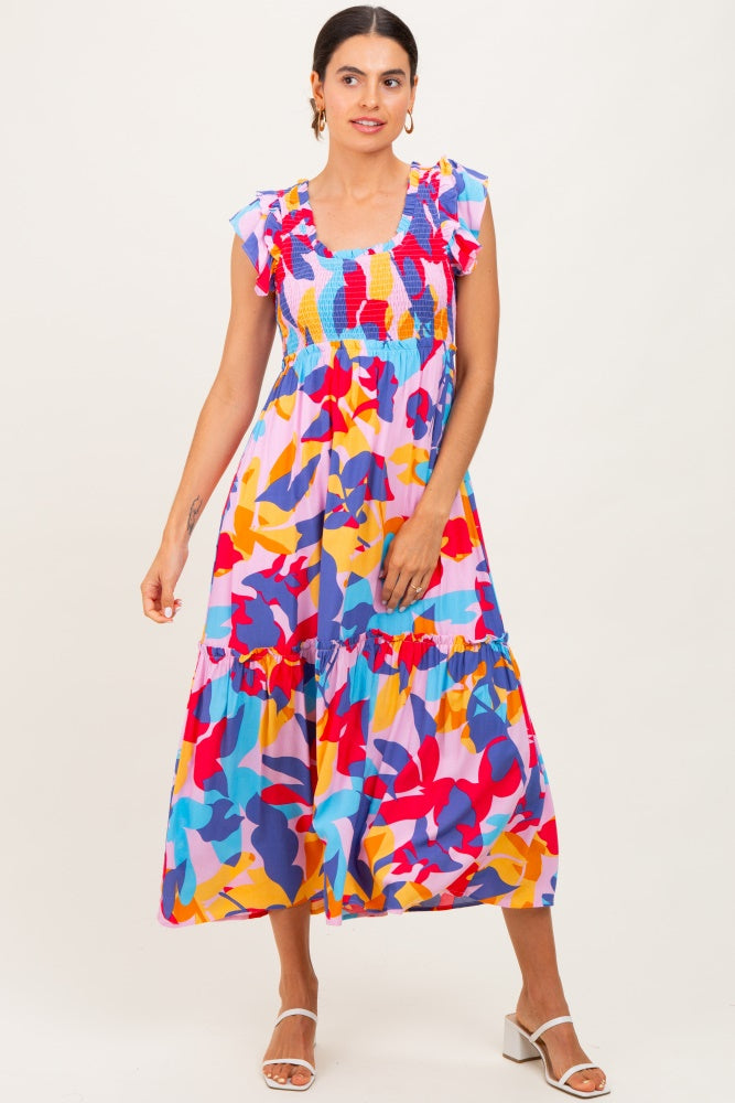 woman wearing a colorful floral maxi dress with ruffled sleeves and a smocked bodice