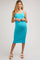 woman wearing a light blue textured maternity dress with a fitted silhouette and adjustable straps, showing her baby bump