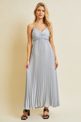 woman wearing a light grey pleated maxi dress with spaghetti straps and a sweetheart neckline