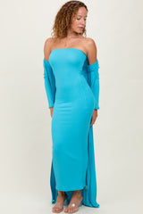 woman wearing a turquoise off-the-shoulder fitted maxi dress with long sleeves and side slits
