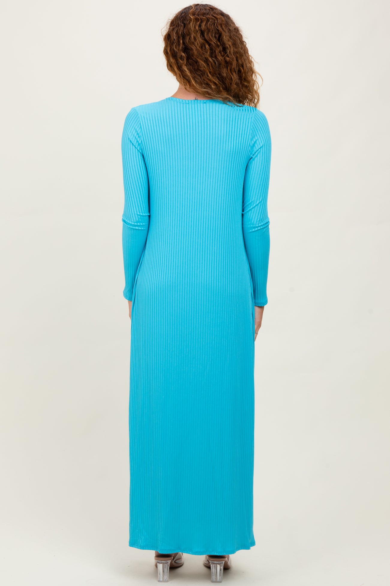 woman wearing a long sleeve ribbed maxi dress in bright turquoise from the back