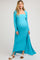 woman wearing a turquoise ribbed maternity gown with a side slit and long sleeves, showcasing her baby bump