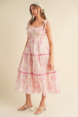 woman wearing a pink floral print maxi dress with ruffled straps and tiered layers