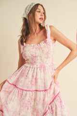 woman wearing a pink floral print smocked dress with ruffled straps and layered tiers