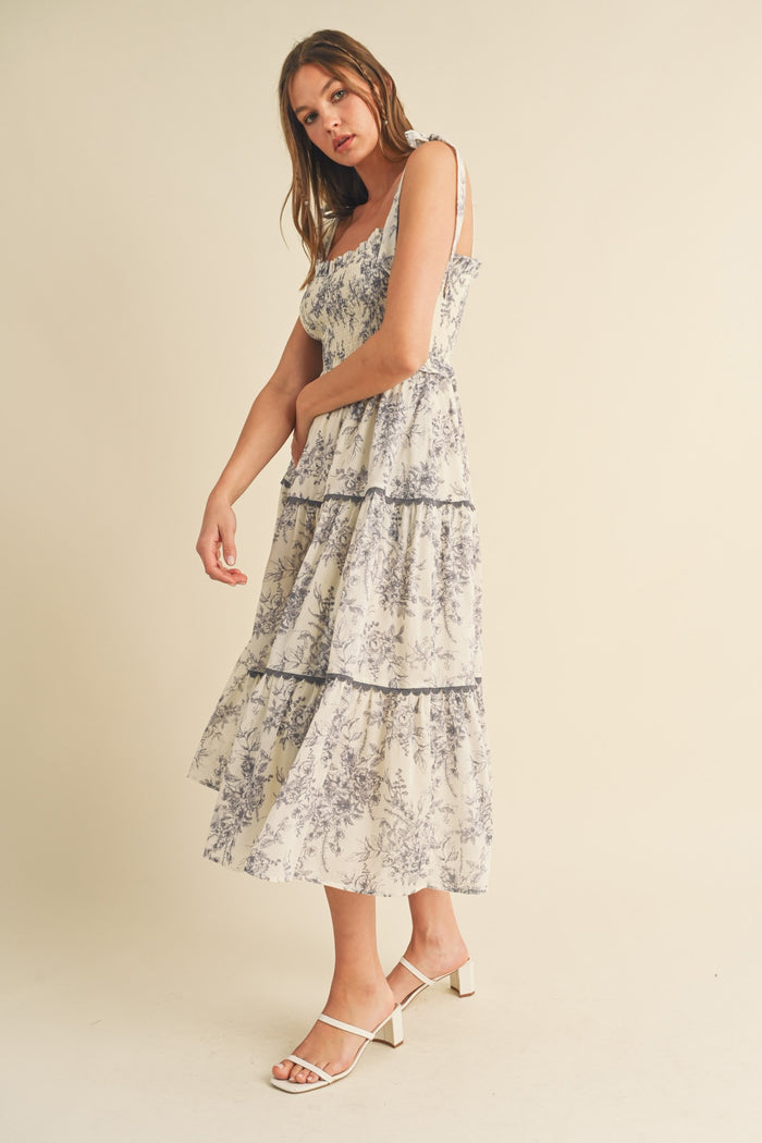 woman wearing a floral print tiered maxi dress with spaghetti straps and white sandals