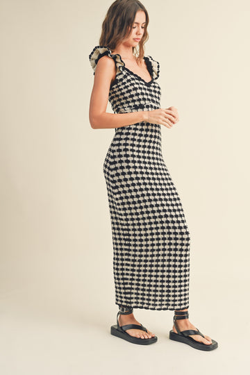woman wearing a black and white checkered maxi dress with ruffle straps and flat sandals