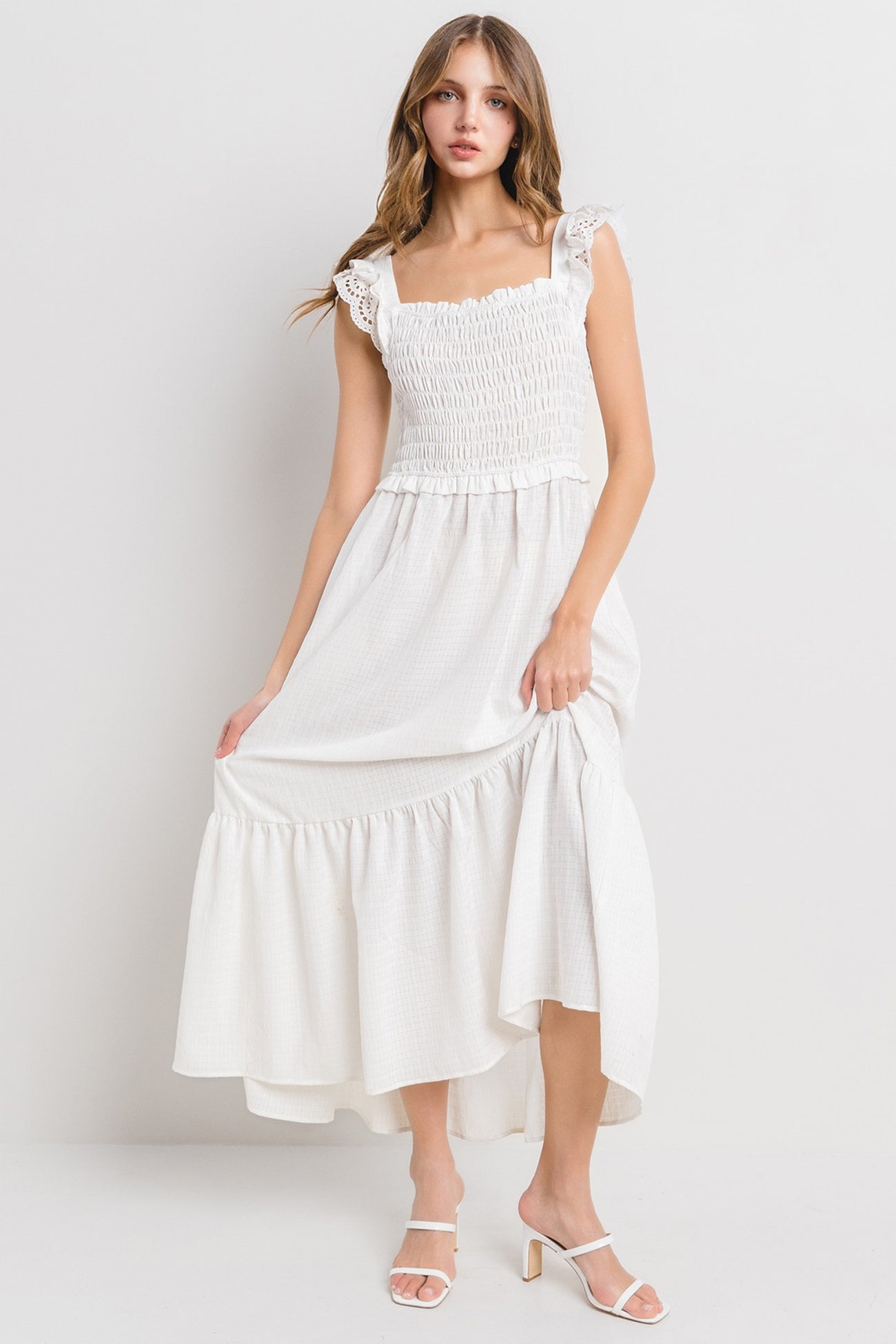 woman wearing a white smocked maxi dress with ruffled straps and a flowy hemline