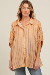 woman wearing a light orange striped maternity button-up shirt with short sleeves and relaxed fit
