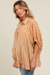 woman wearing a light orange striped maternity top with a loose fit and a visible baby bump