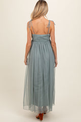 woman wearing a light teal maternity maxi dress with adjustable tie straps and a smocked back