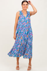 woman wearing a flowy floral sleeveless midi dress in vibrant blue with colorful patterns and relaxed fit