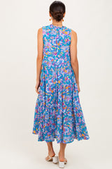 woman wearing a sleeveless blue floral maxi dress with a tiered skirt and a keyhole back detail