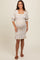 woman wearing a white floral maternity dress with puff sleeves and ruffle hem, showcasing her baby bump