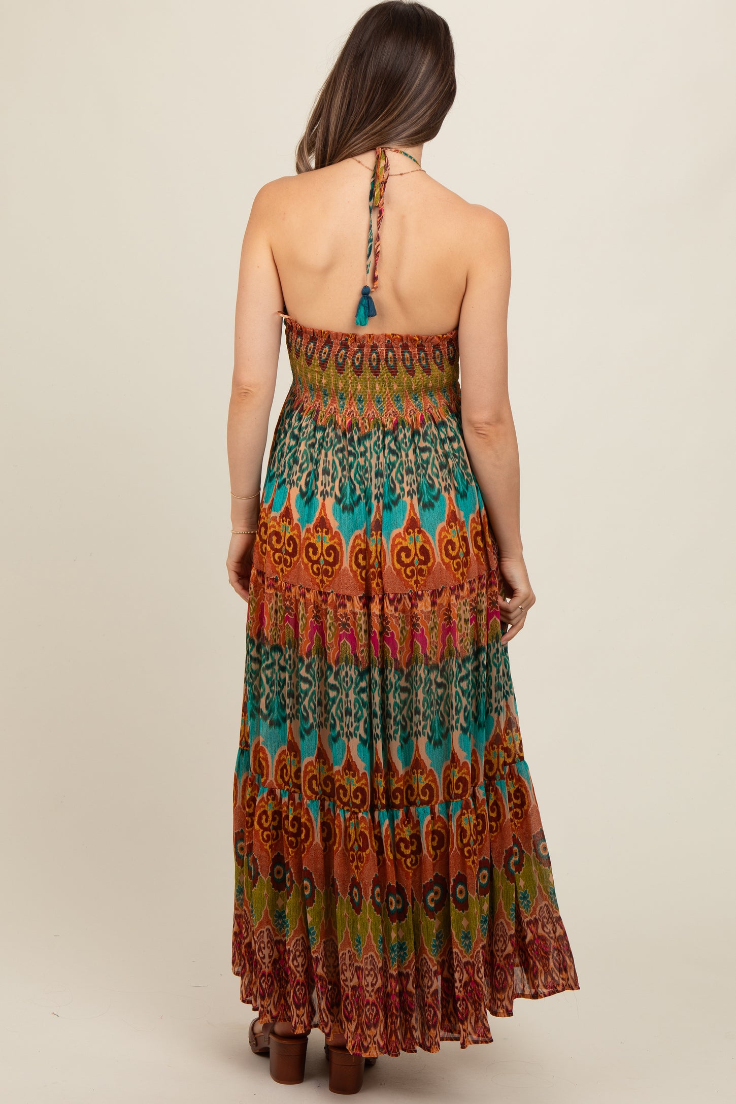 woman wearing a colorful printed strapless maternity maxi dress with a back tie detail