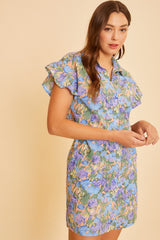 woman wearing a short sleeve floral print dress in blue, green, and purple shades with ruffled sleeves