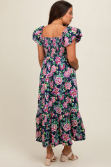 woman wearing a floral print maternity maxi dress with puff sleeves and a ruffled hem