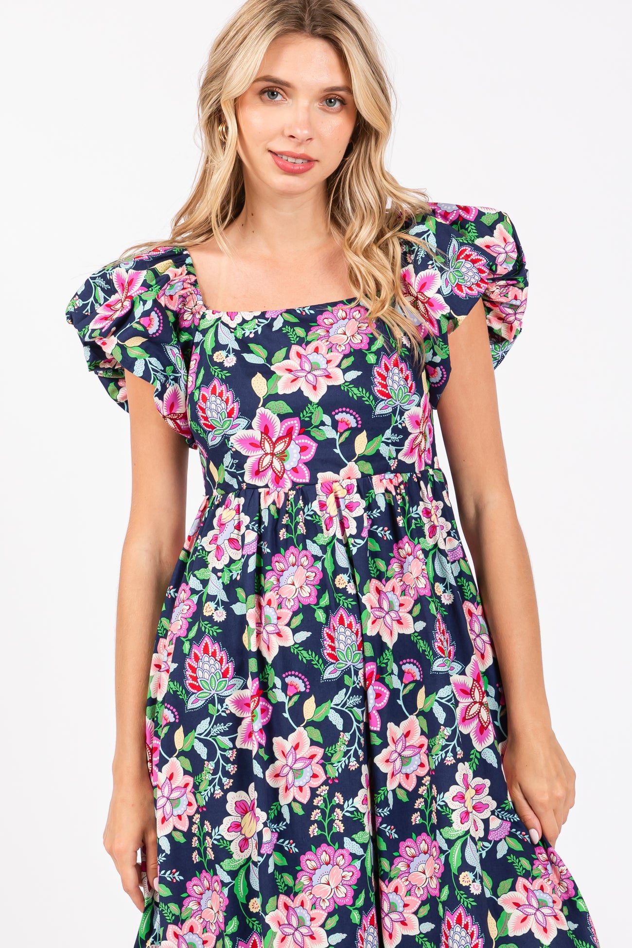 woman wearing a navy blue floral print maxi dress with puff sleeves and a square neckline