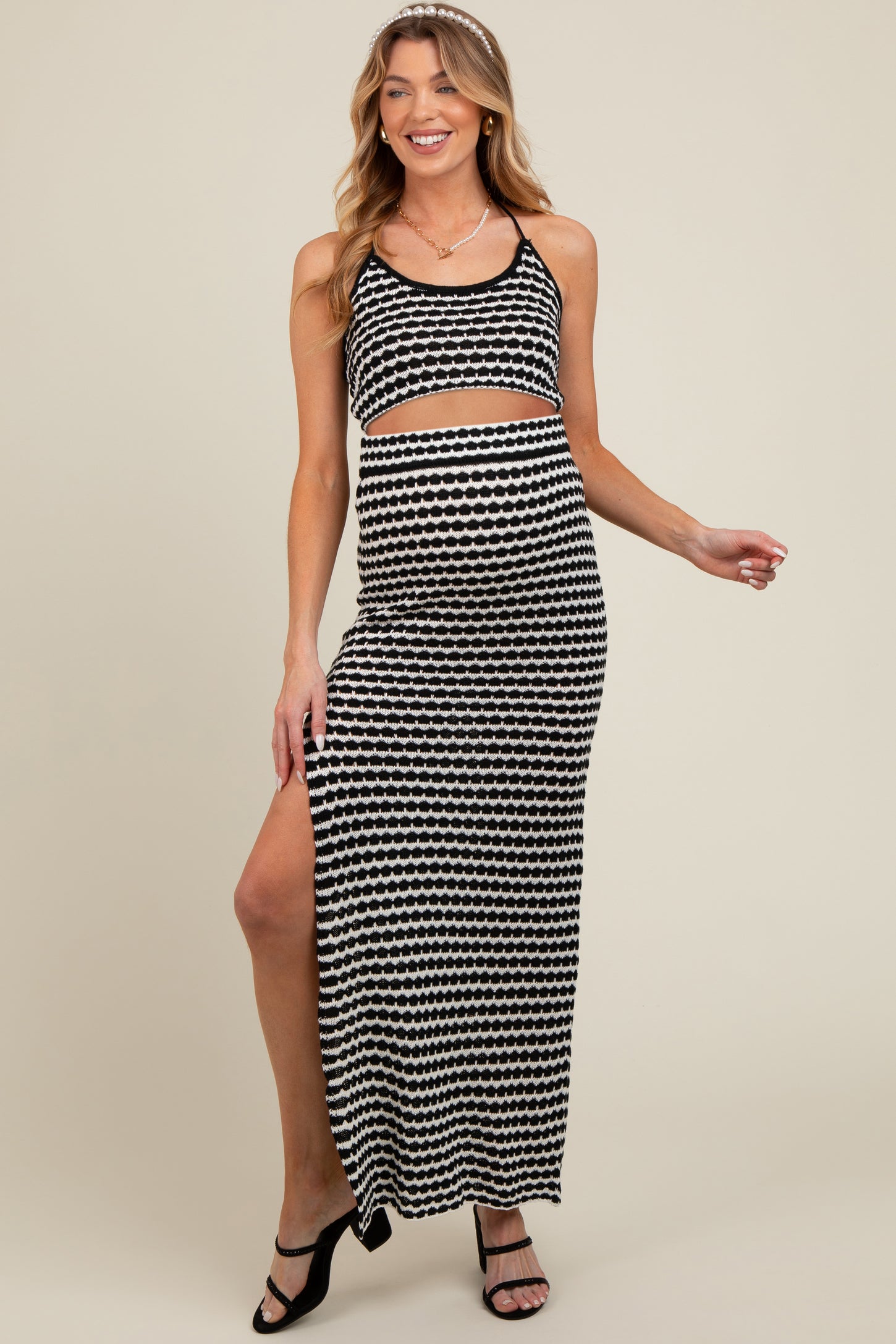 woman wearing a black and white patterned maternity maxi dress with a cut-out detail and a side slit