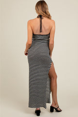 woman wearing a black and white patterned maternity maxi dress with a side slit and halter tie back detail