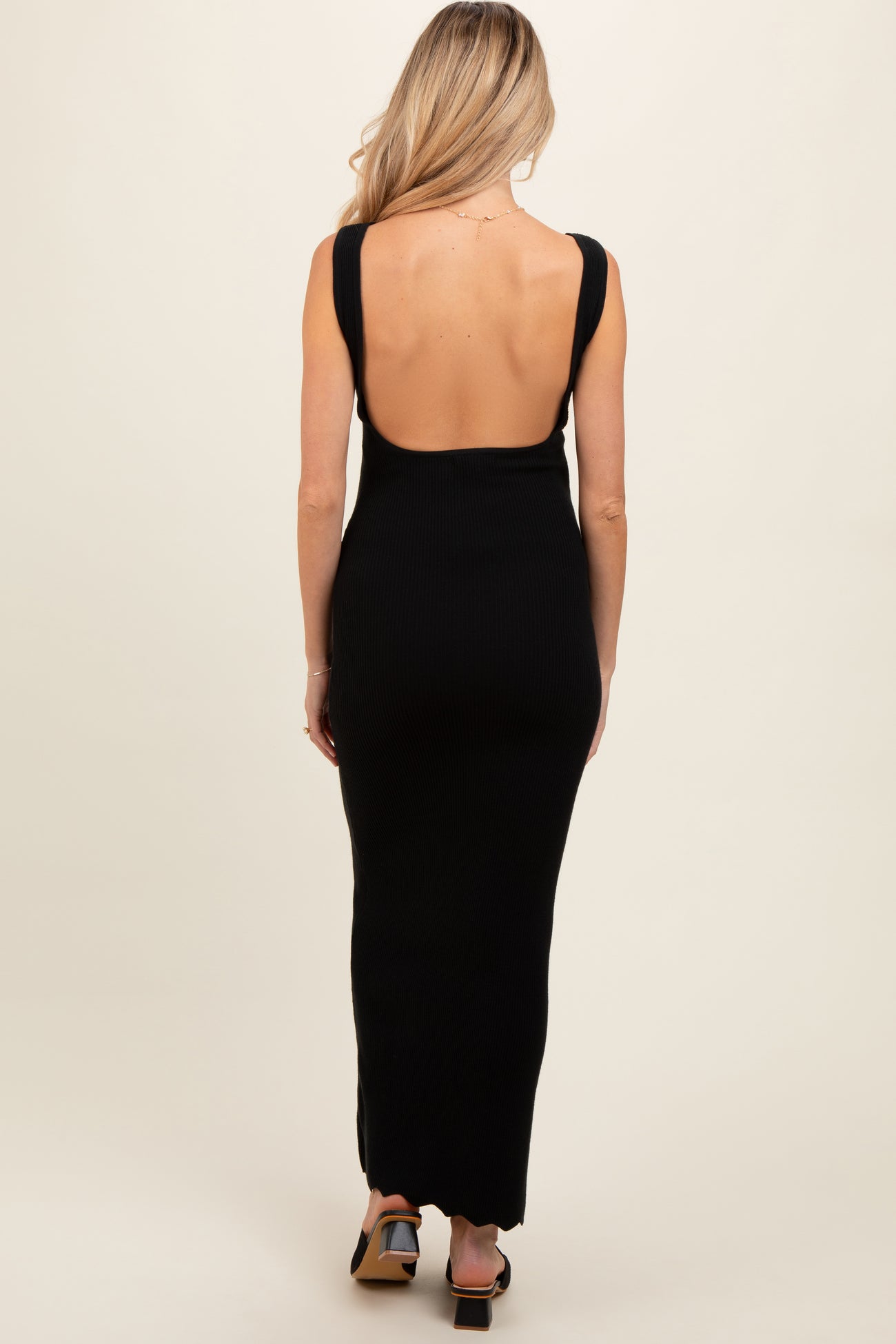 woman wearing a black ribbed backless maternity maxi dress