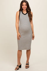 woman wearing a black and white striped maternity dress with a fitted silhouette and a round neckline, showing a baby bump