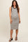 woman wearing a black and white striped maternity dress with a fitted silhouette and a round neckline, showing a baby bump