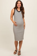woman wearing a black and white striped maternity dress with a fitted style and holding her baby bump