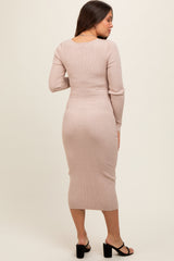 woman wearing a light pink ribbed maternity dress, showing off her baby bump from the back