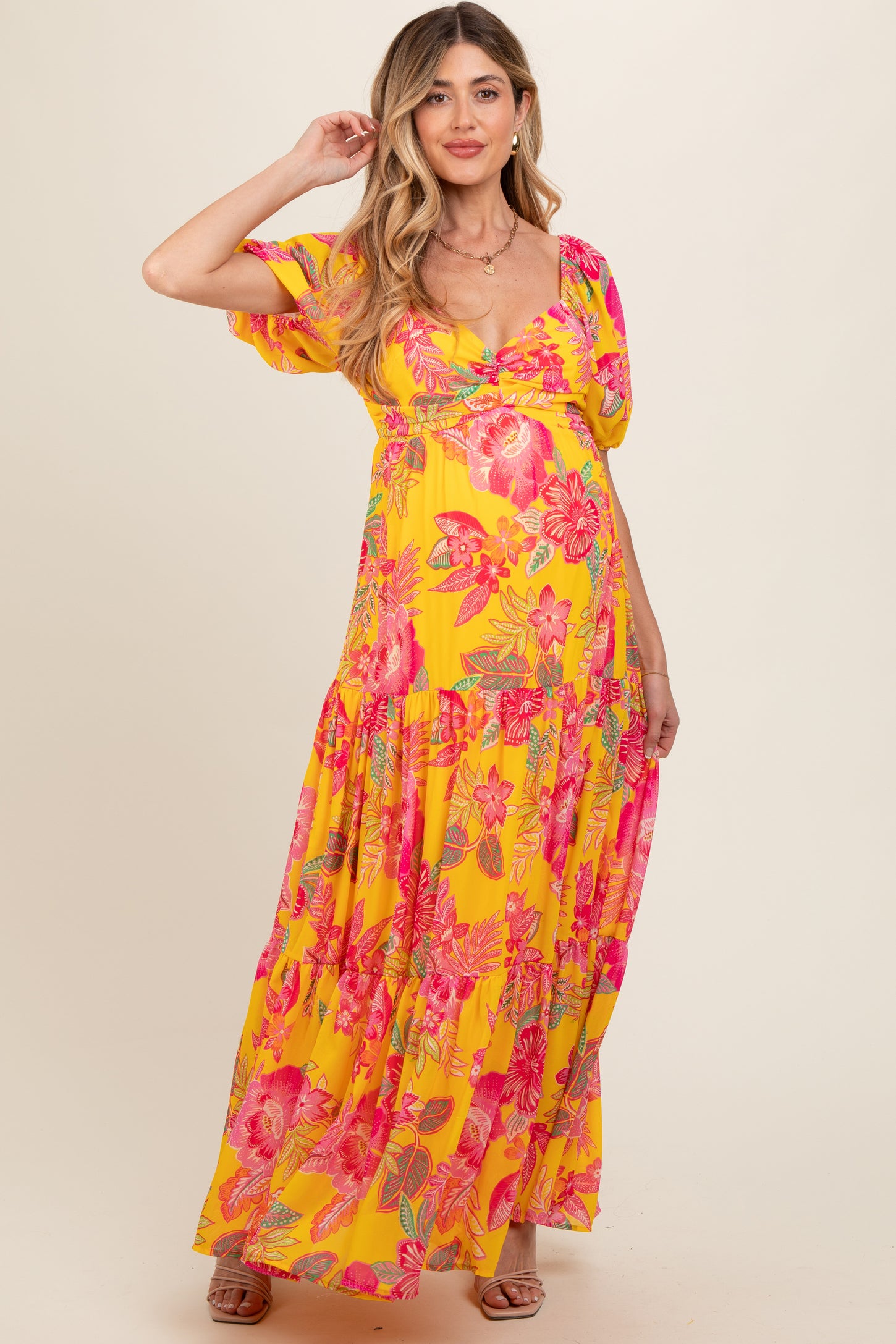 woman wearing a yellow floral maxi dress with puff sleeves and a baby bump visible