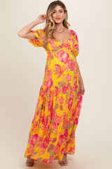 woman wearing a yellow floral maxi dress with puff sleeves and a baby bump visible