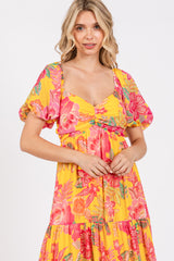 woman wearing a bright yellow floral maxi dress with puff sleeves and a sweetheart neckline