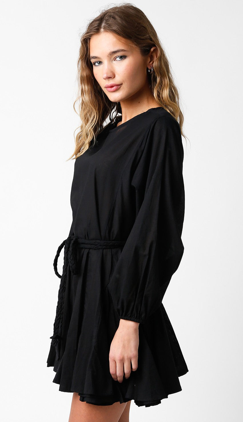 woman wearing a black long sleeve dress with a tie waist and a flared skirt